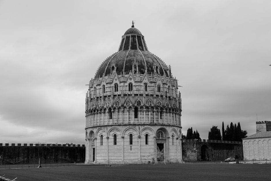 Monochrome photo of the Pisa Baptistery showcasing its Romanesque architecture.